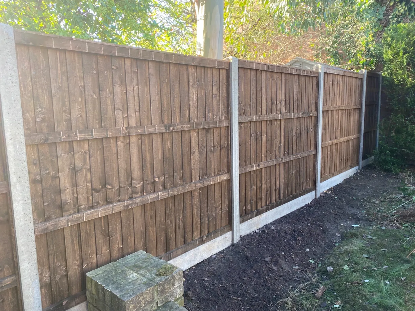 Brown closeboard fence panels fitted with concrete posts and gravel boards in a residential garden