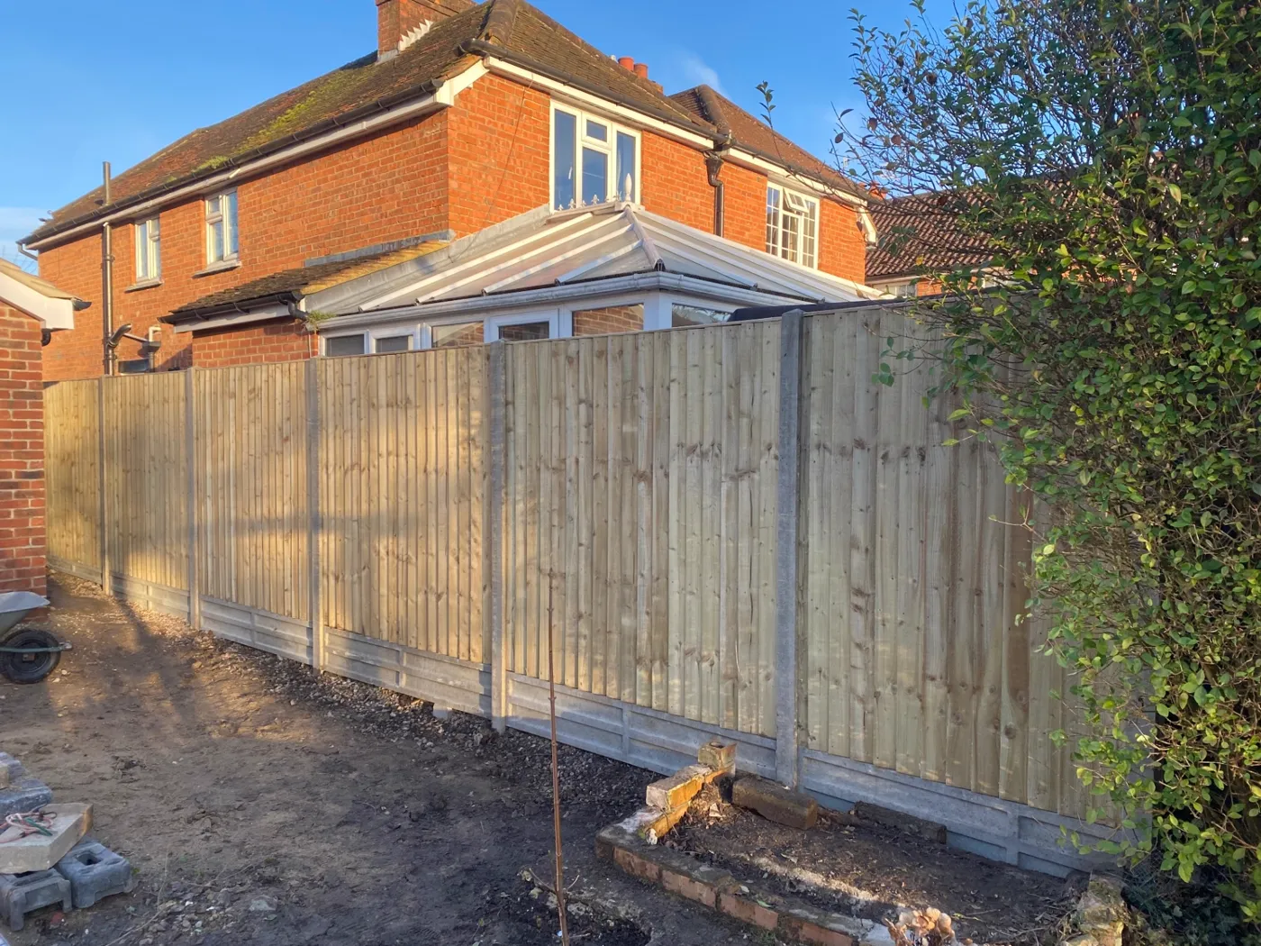 New closeboard garden fence with concrete posts and gravel boards in a residential garden